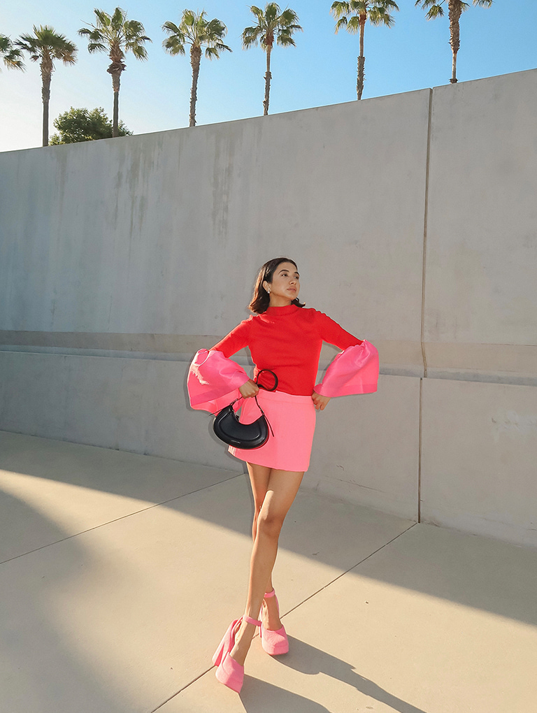 Women’s Petra curved shoulder bag in black and Loey ankle-strap platform pumps in pink, as seen on Navdeep Kaur – CHARLES & KEITH